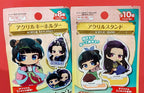 Two packages of acrylic stands with character figures on a red background